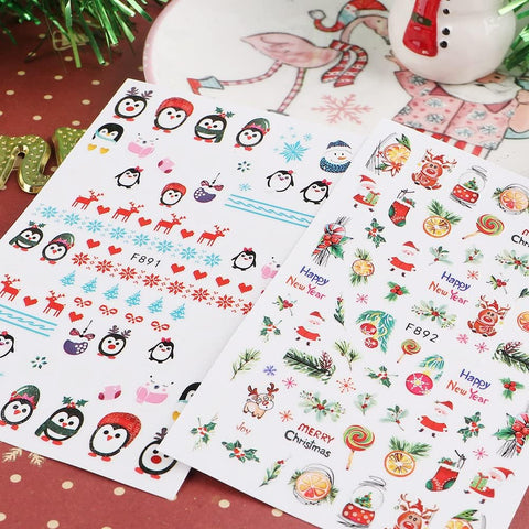 Two sheets of Christmas-themed stickers with penguins, reindeer, and other holiday designs on a polka dot surface.