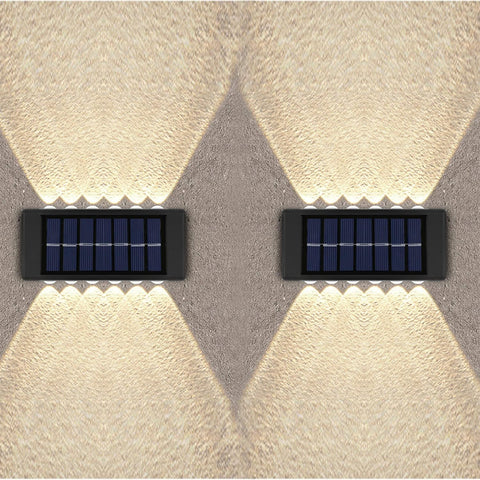 Two solar-powered wall lights on a textured wall.