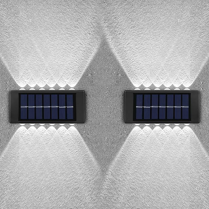 Two solar panels mounted on a textured white wall.