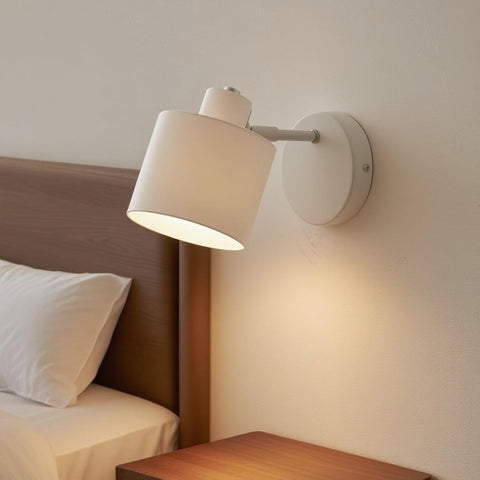 Wall-mounted lamp on a bedroom wall next to a bed