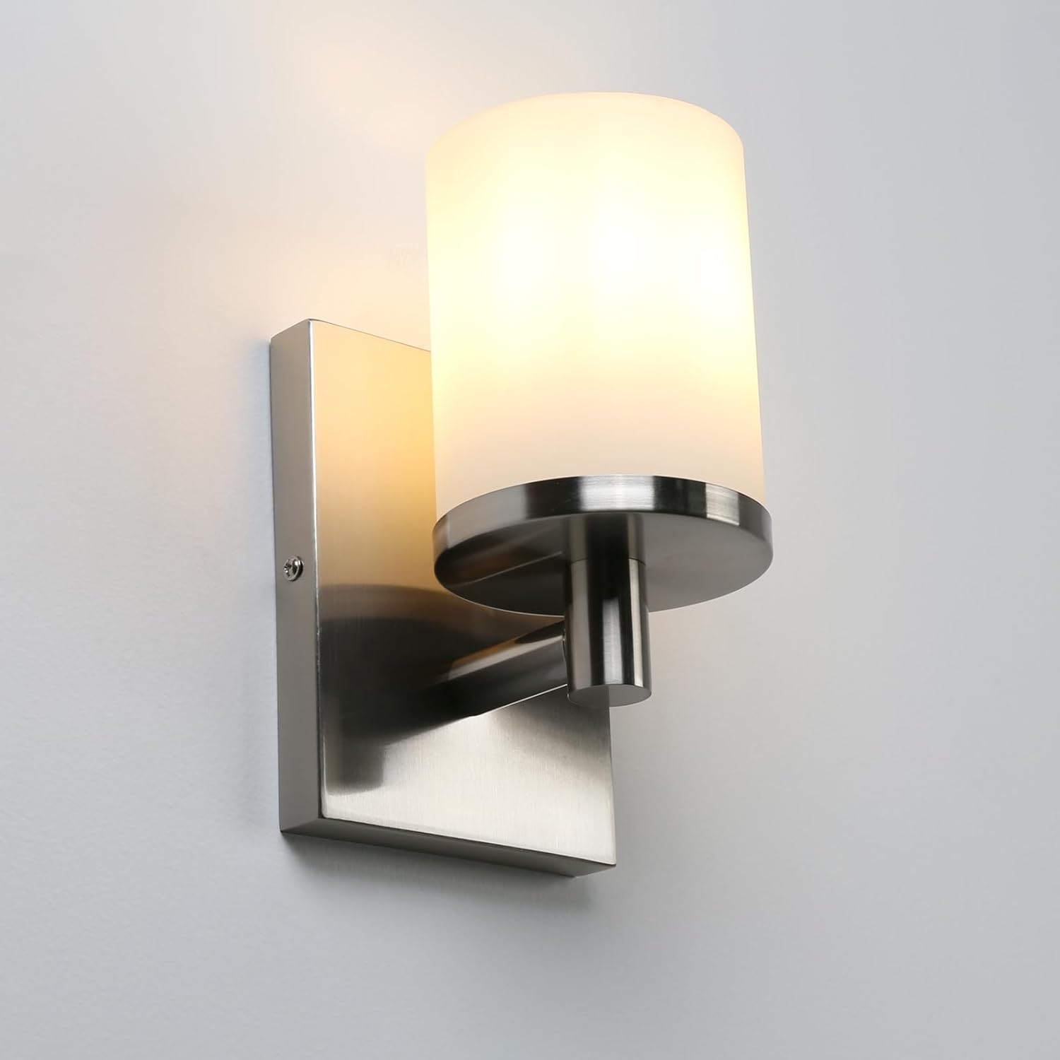 Wall-mounted light fixture with a glass shade on a gray background