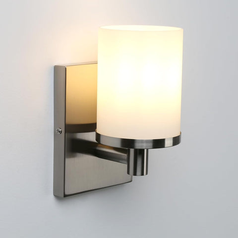 Wall-mounted light fixture with a white glass shade on a gray background