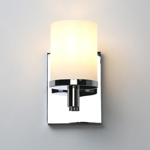 Wall-mounted light fixture with a white shade on a gray background