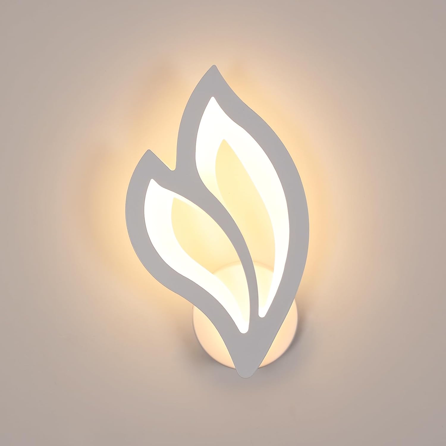 Wall-mounted light fixture with leaf design on a neutral background
