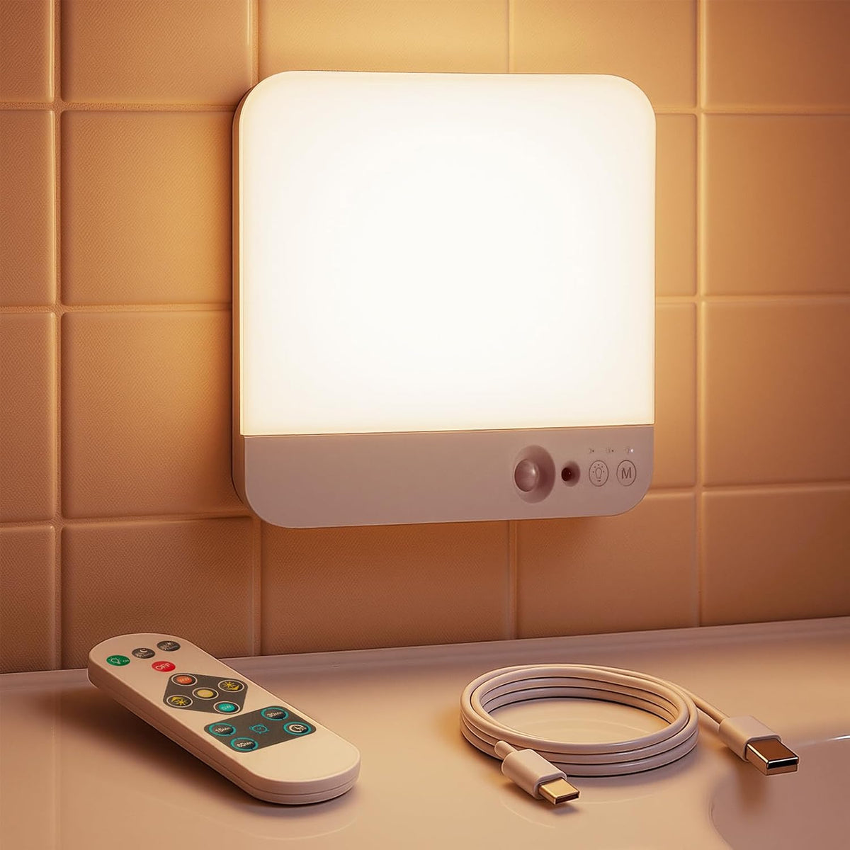 Wall-mounted light fixture with remote control and cable on a tiled wall background