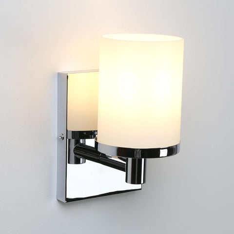 Wall-mounted light fixture with white glass shades on a gray background