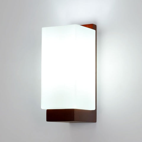 Wall-mounted light fixture with white shade and brown metal frame on a gray background