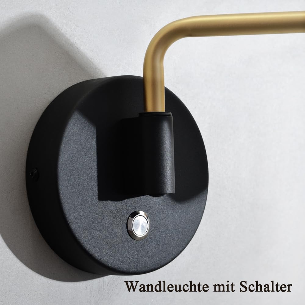 Wall light fixture with black base and gold arm on a gray background