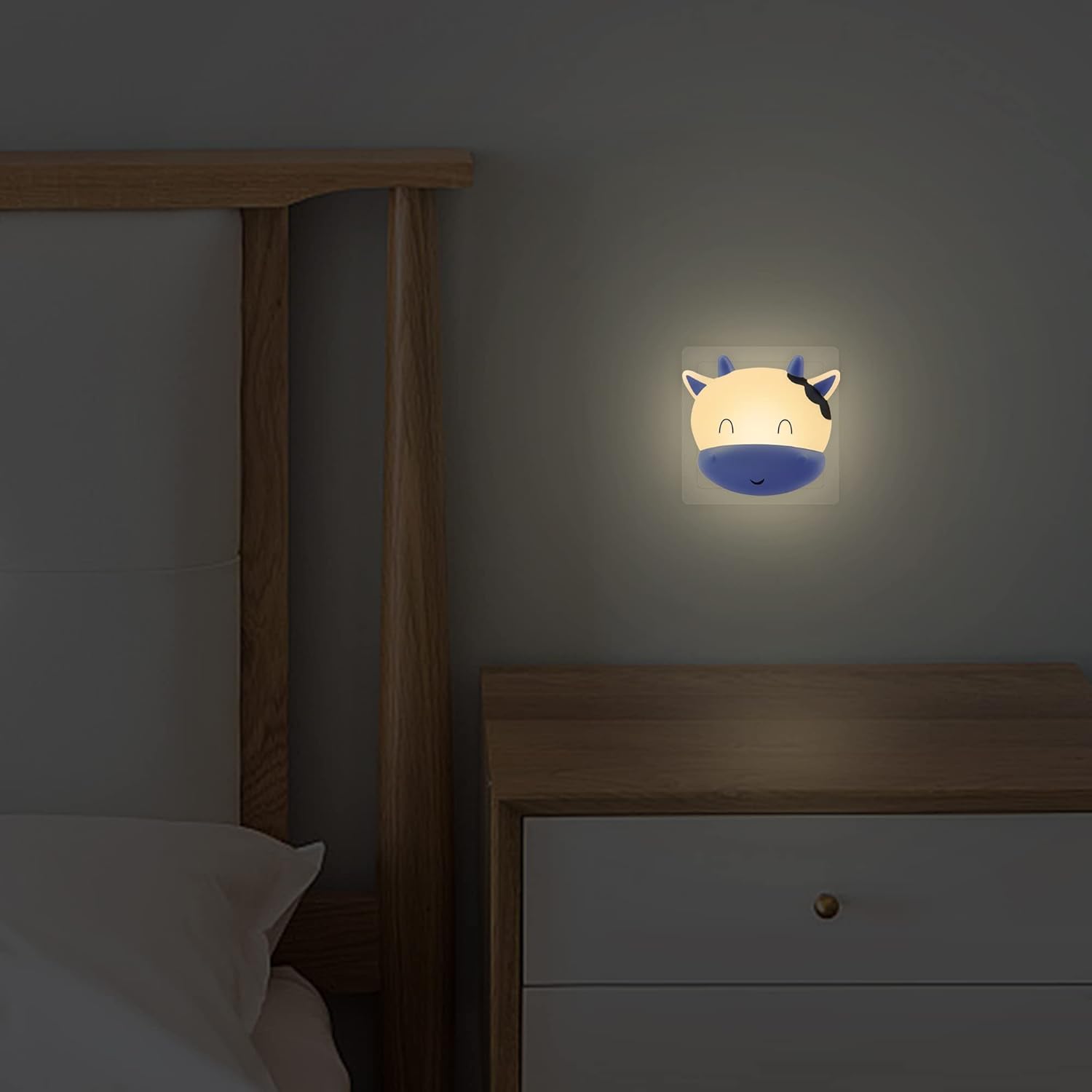 Wall night light shaped like a cow's face in a bedroom setting.