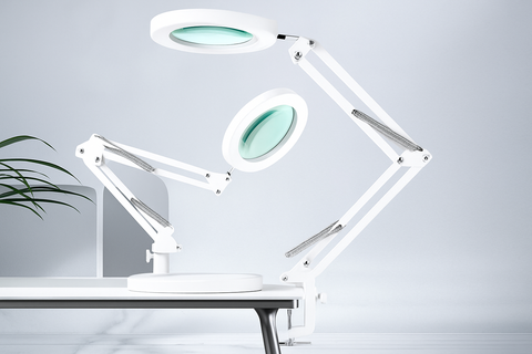White adjustable magnifying lamp on a desk with a light gray background