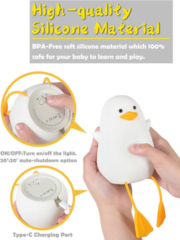 White duck-shaped night light with yellow accents, held by a hand, on a white background.