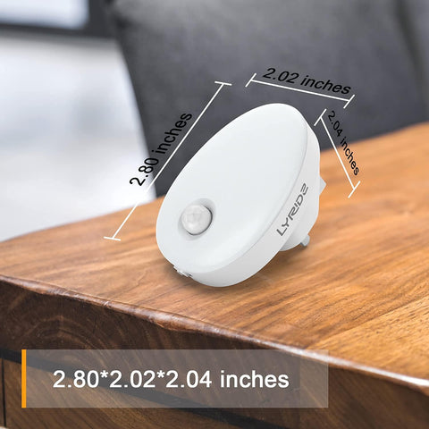 White motion sensor light on a wooden surface with dimensions displayed