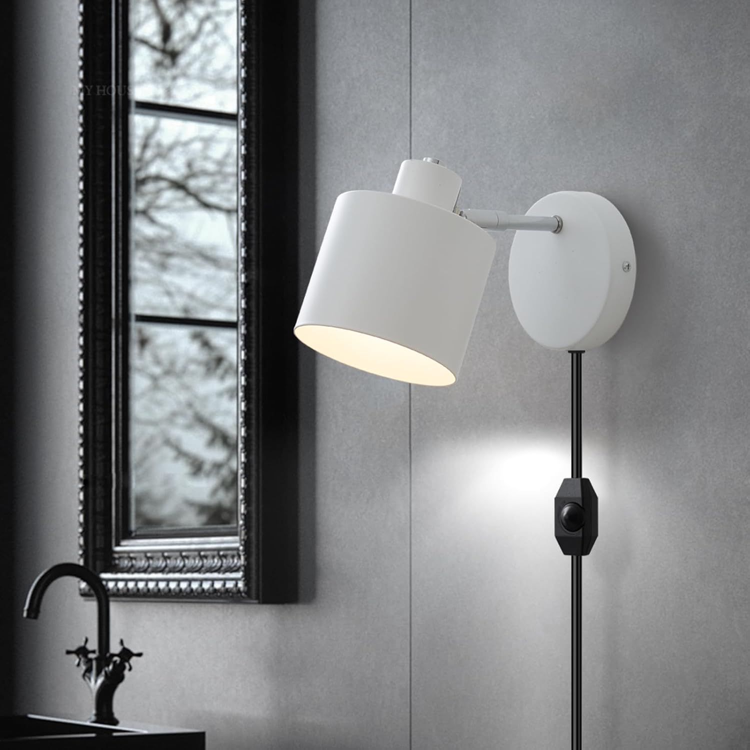 White wall lamp on a gray wall with a window in the background