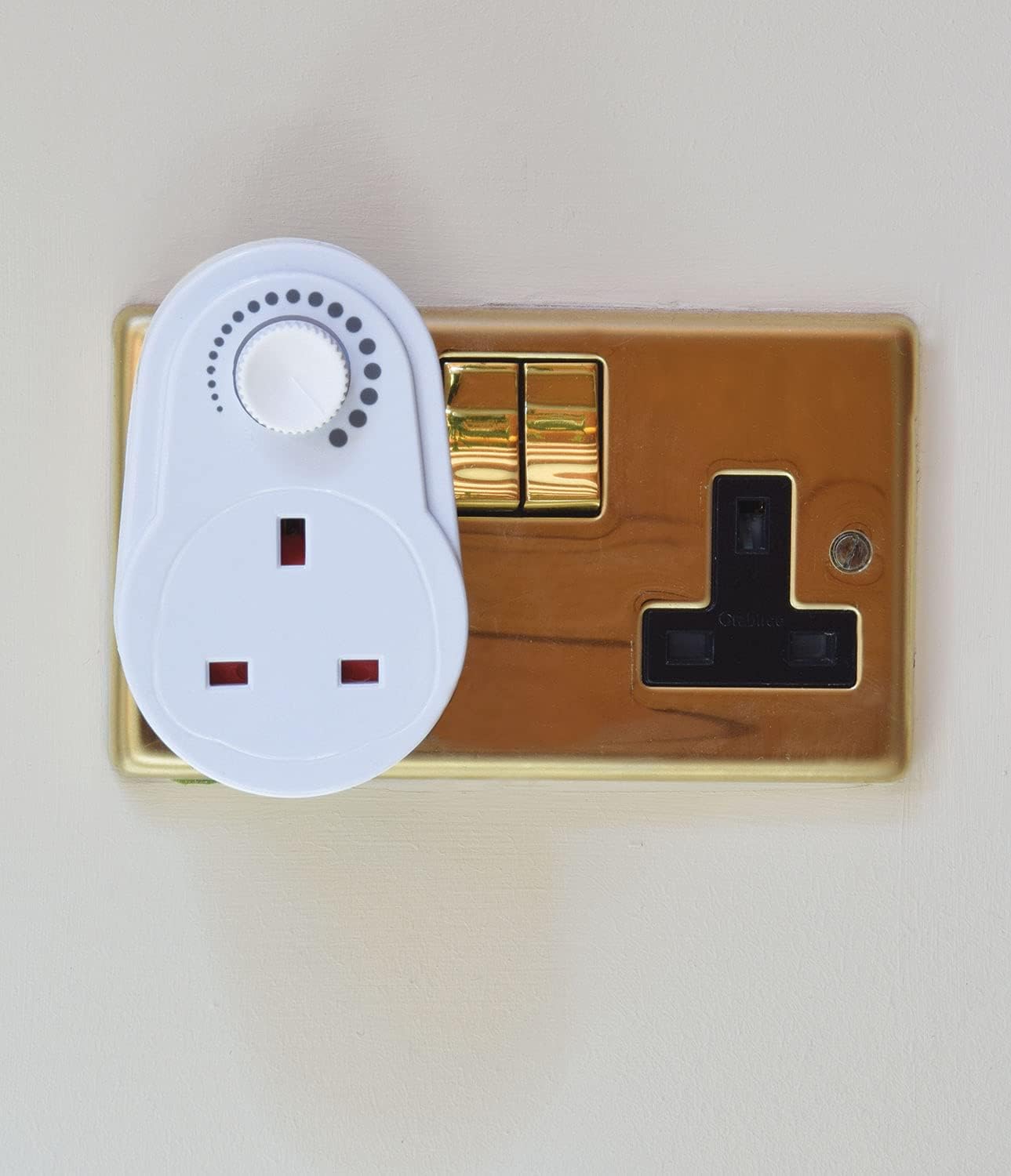 White wall socket cover on a gold electrical outlet