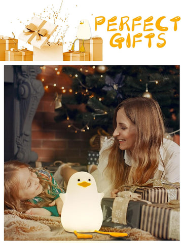 Woman and child with a penguin-shaped night light in front of a Christmas tree.
