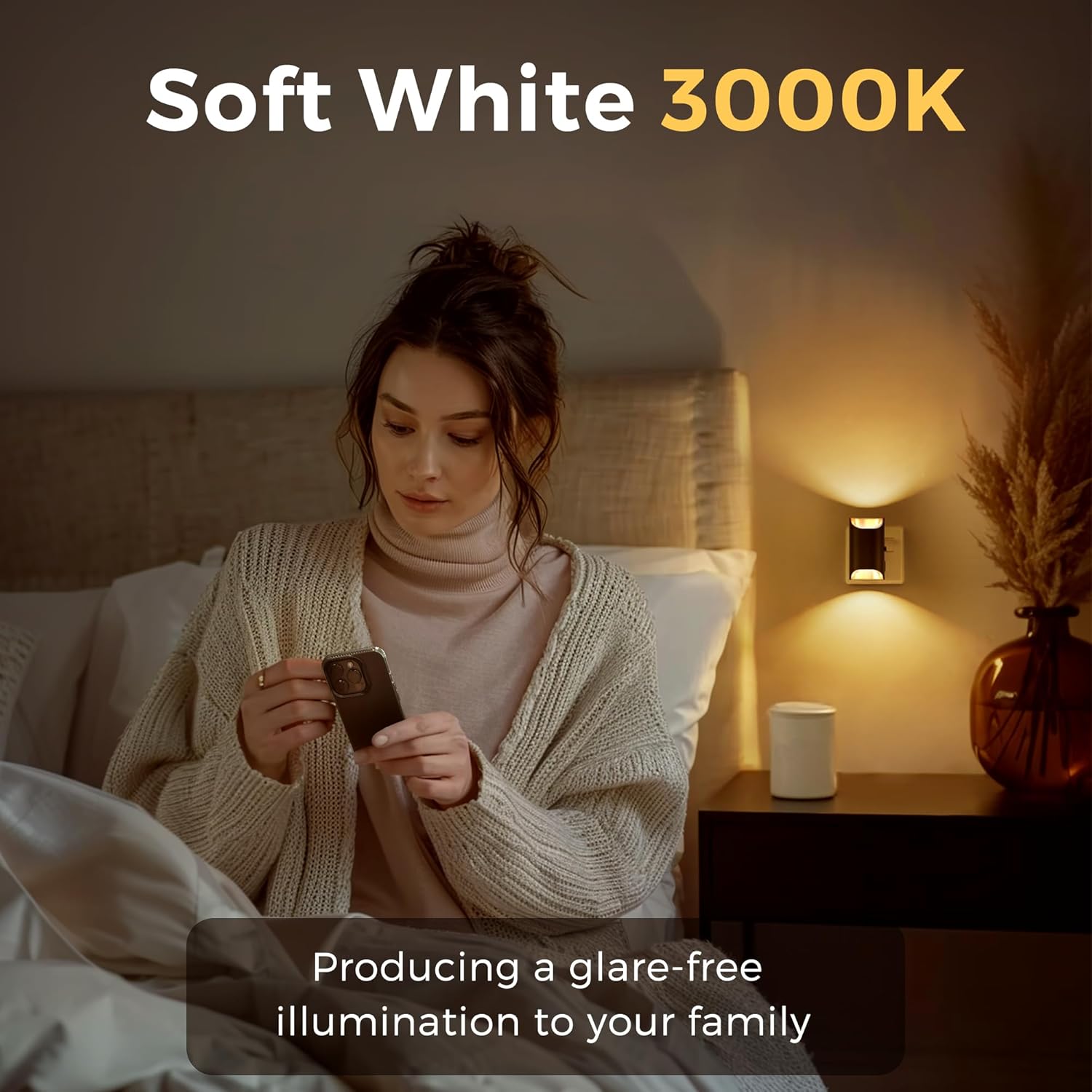 Woman sitting on a bed using a smartphone with soft white 3000K lighting.