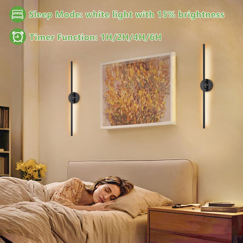 Woman sleeping in a bedroom with wall-mounted lights and a painting on the wall.