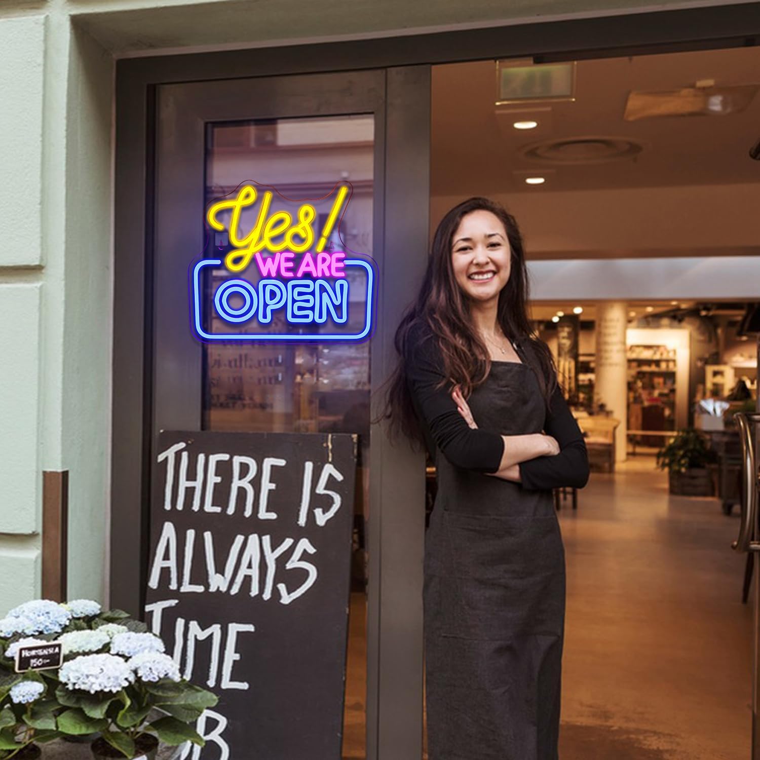 Woman standing in front of a store entrance with a neon sign and motivational quote.