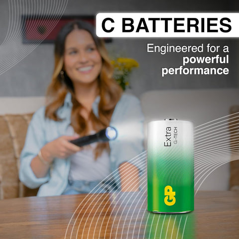 Woman using a flashlight with a Gtech battery in the foreground, text 'C Batteries Engineered for a powerful performance' above.