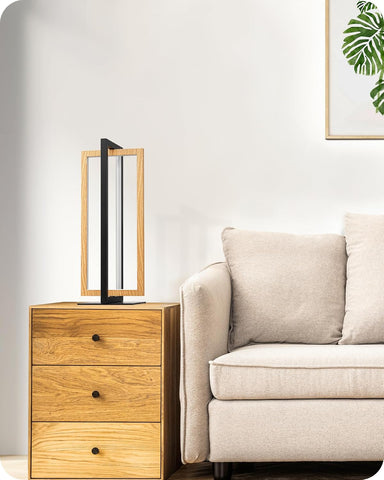 Wooden side table with a lamp next to a beige sofa in a living room setting.