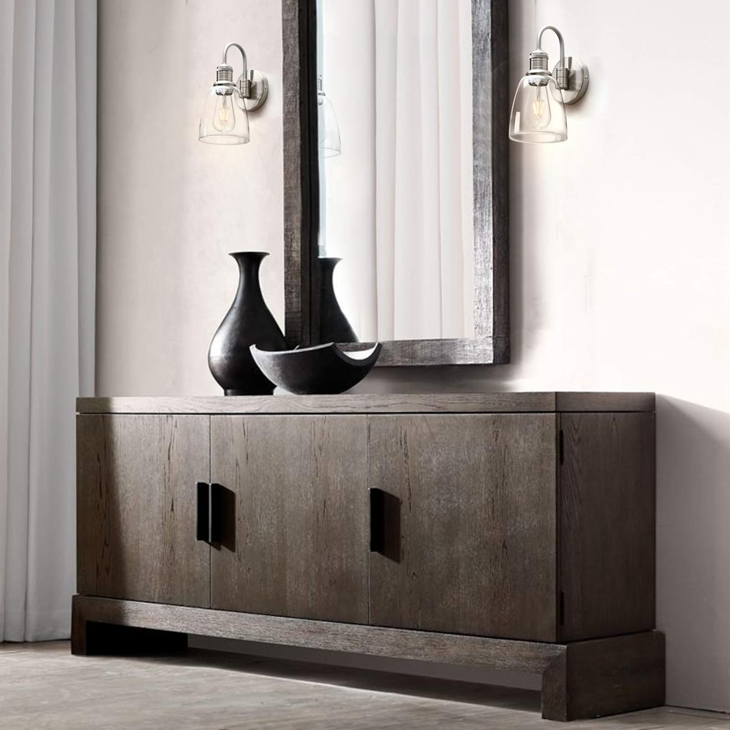 Wooden sideboard with decorative vases and a mirror in a room setting.