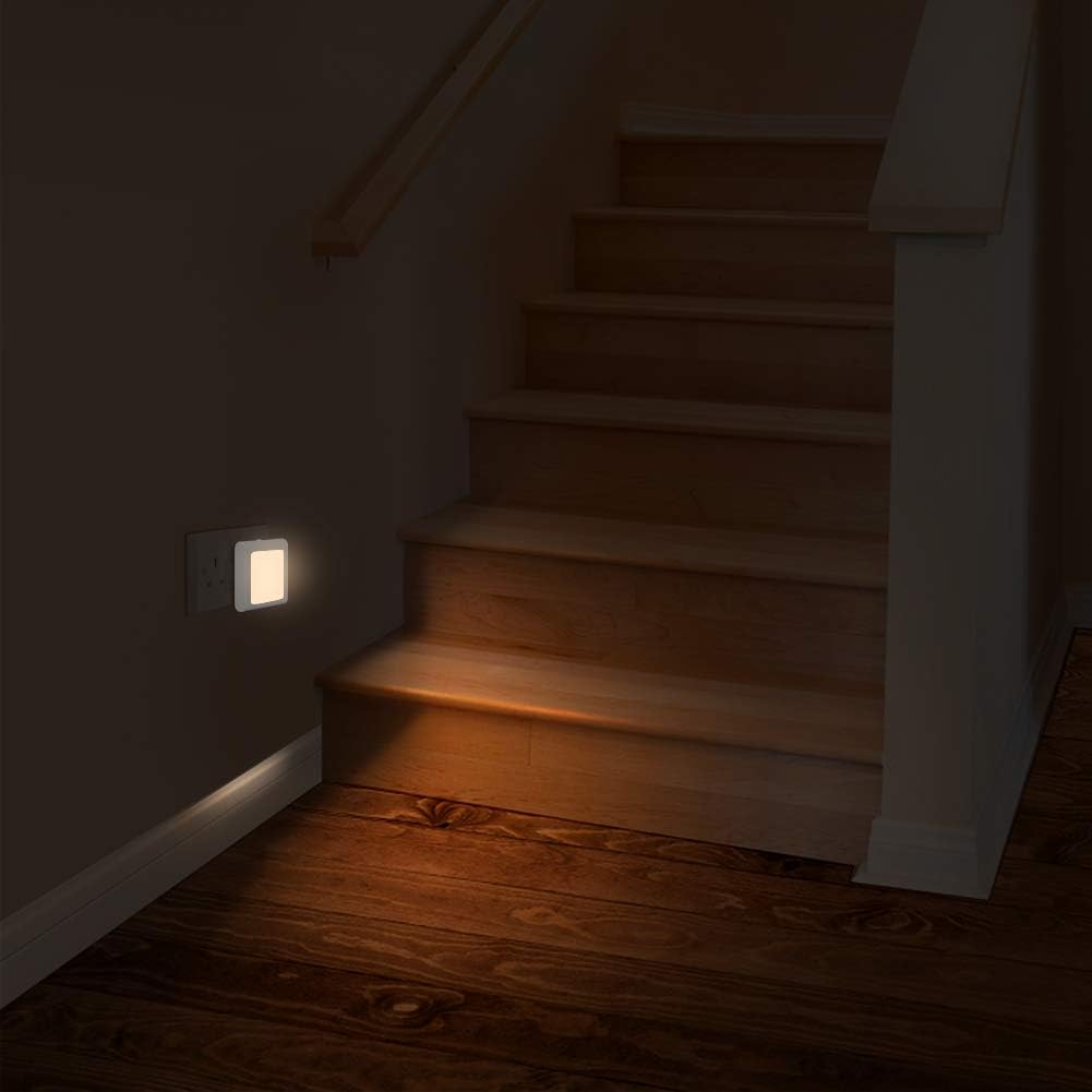 Wooden staircase with a light switch on a dark wall
