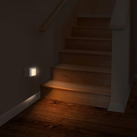 Wooden staircase with a light switch on a dark wall