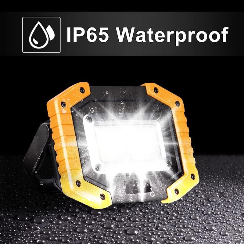 Yellow and black waterproof LED work light on a black background with water droplets.
