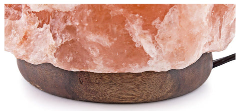 Close-up of the hand-carved Himalayan salt crystal lamp on a wooden base.


