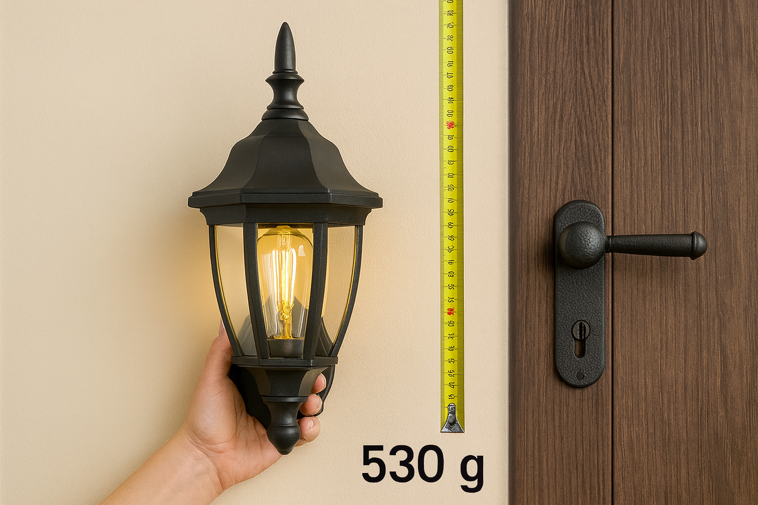 Hand holding a black outdoor wall light fixture next to a door with a measuring tape showing weight.
