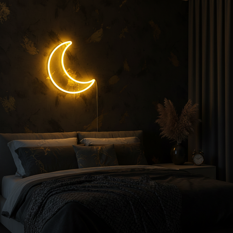 Neon moon light on a dark wall above a bed in a dimly lit room.