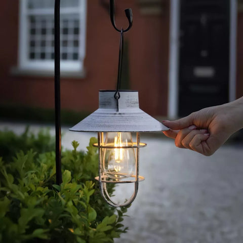 Close-up of the 20cm solar lantern glowing in a garden setting

