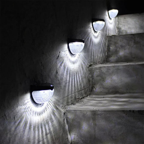 Waterproof solar wall lights illuminating a garden fence

