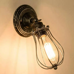 Vintage industrial wall light with metal cage – UK interior.

