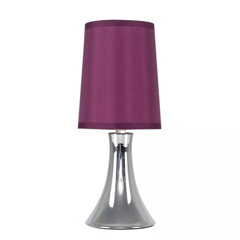 Lamp illuminating a cozy bedroom setting.​

