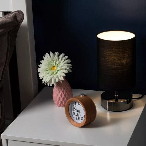 Close-up of the lamp's matte black base and cylindrical fabric shade.​

